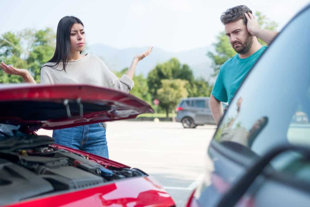 Angry stressed woman having a quarrel with one man after car crash
